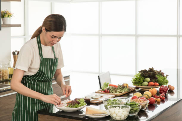 istock Woman making a dish of vegetable salad. 1221099639
