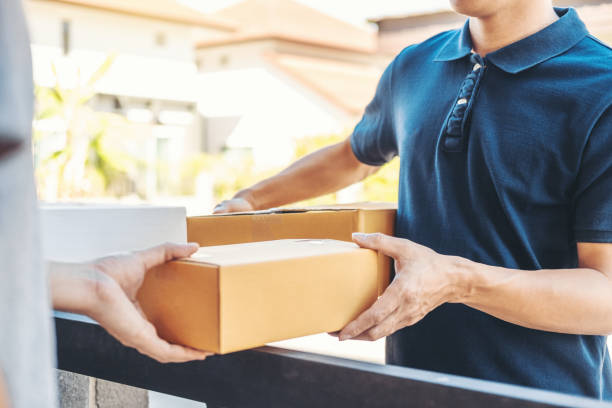 istock Delivery concept Asian Man hand accepting a delivery boxes from professional deliveryman at home 1221101897