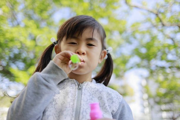 istock Japanese girl playing with bubble in the green (5 years old) 1221102716
