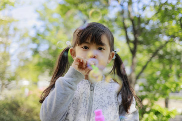 istock Japanese girl playing with bubble in the green (5 years old) 1221102731