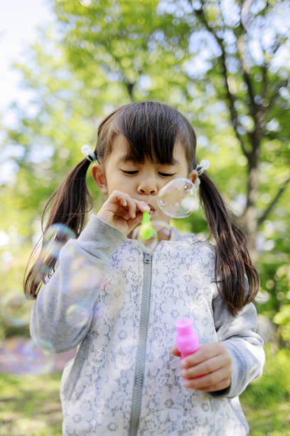 istock Japanese girl playing with bubble in the green (5 years old) 1221102780
