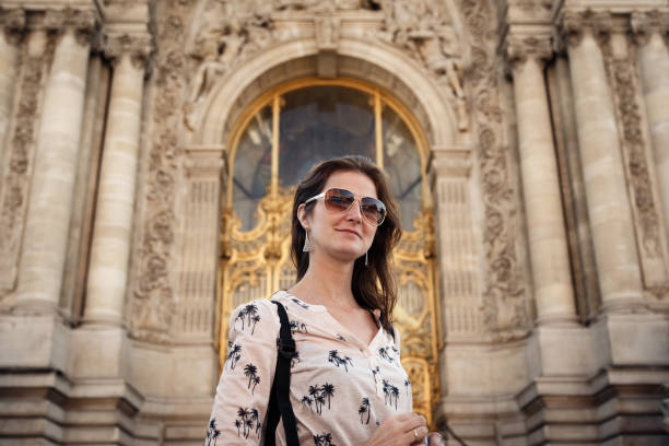 Portrait of woman charging her electric car in Paris