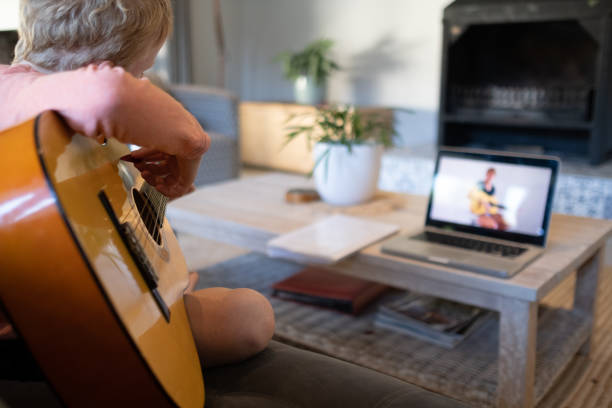 istock Boy practicing his guitar via teleconference with his music teacher 1221118461
