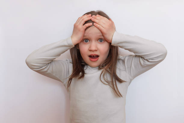 istock Little girl clasps her head 1221119554