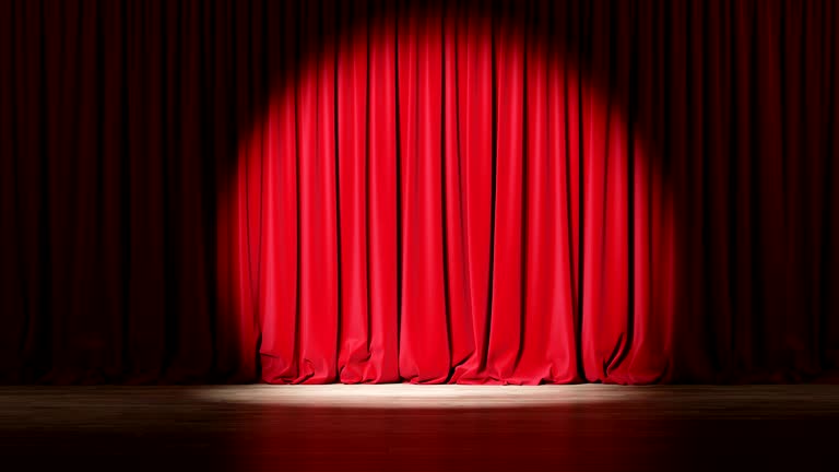 Empty theater stage with red velvet curtains with spotlights.