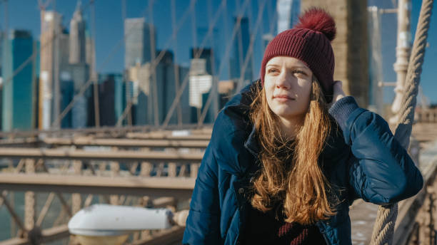 istock Beautiful girl on Brooklyn Bridge enjoys a sunny day while relaxing 1221121354