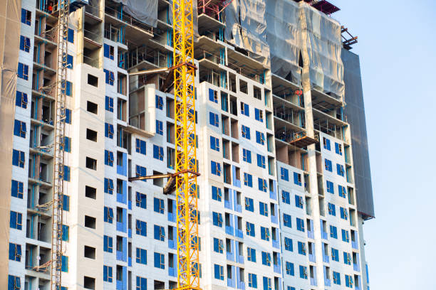 istock High rise construction building site with crane against blue sky 1221126415