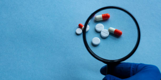 istock Pharmacist or expert on pharmaceutical inspection identifies pills. Testing, verification and determining pharmaceutical counterfeiting or fakes of medicines and medicinal substance quality concept 1221129281