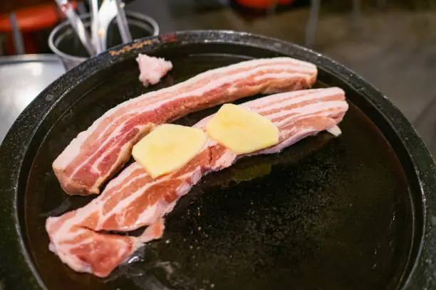 Photo of Samgyeopsal, grilled pork belly. Three layer flesh referring to striations of lean meat and fat in the pork belly.