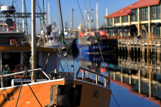 Inshore fishing boat moored at a stone pier at Kircubbin, County Down (Northern Ireland).  In the distance is Strangford Lough and the outline of the Mourne Mountains.