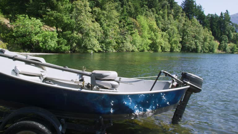 A Vehicle Backs a Trailer and a Small Boat up Down a Boat Ramp and into the Columbia River in Washington on a Sunny Day