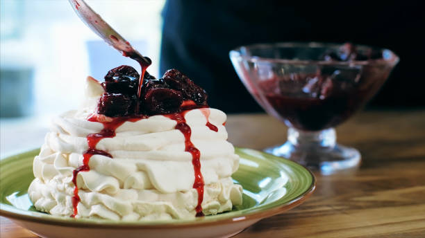 istock Chef cooking cake with cream. Cook puts a cherry jam on cake. 1221133488
