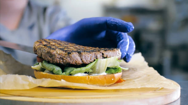istock Female chef is preparing a delicious burger at restaurant kitchen 1221134021