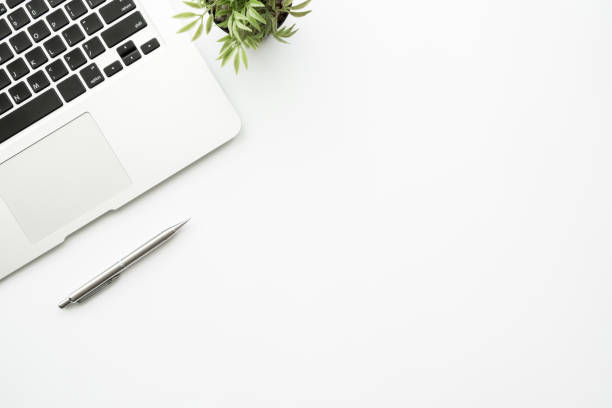 istock White office desk table with laptop computer and pen. Top view with copy space, flat lay. 1221135511