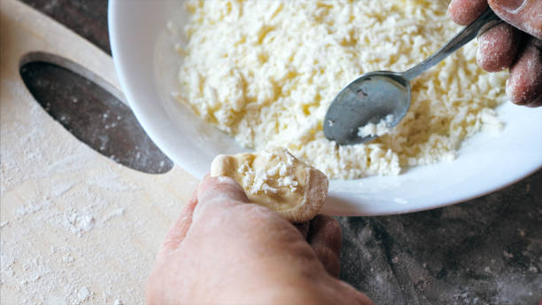 istock Mature female hands making dumplings with cheese at home kitchen 1221138395