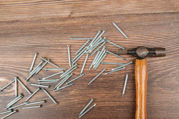 istock Hammer with nails on brown wooden table. Construction tools 1221140353