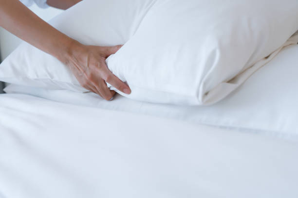 istock Female Hand set up white bed sheet in bedroom 1221140556