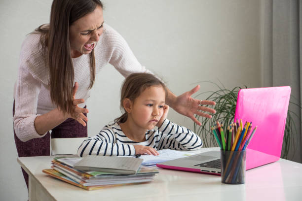 istock Angry mother and bored daughter during online lesson 1221140733