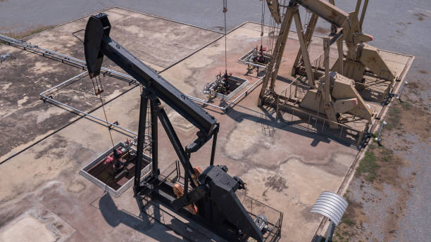 pumpjack ndustrial oil pump jack working and pumping crude oil for fossil fuel energy with drilling rig in oil field - fuel pump gasoline fossil fuel natural gas imagens e fotografias de stock