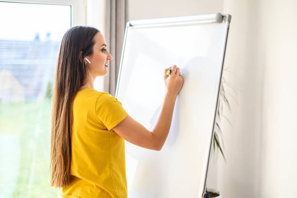 istock Woman with a marker making notes on a white board 1221146296