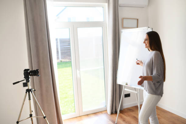 istock Young woman with flipchart records video lessons 1221146371