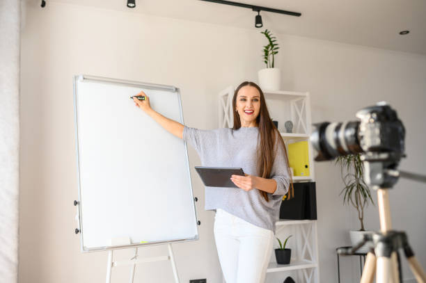 istock Young woman with flipchart records video lessons 1221146403