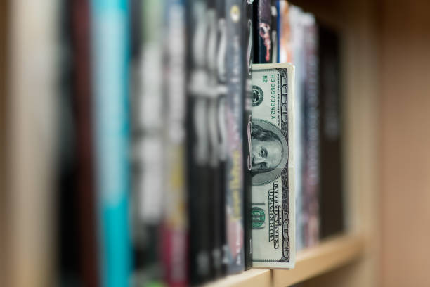 una pila di banconote da 100 dollari che sporge da una libreria - hiding foto e immagini stock