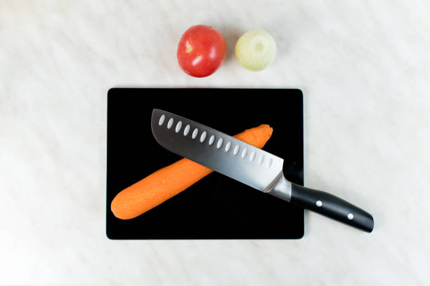 istock A knife and vegetables lie on an old tablet, which serves as a cutting board 1221148080