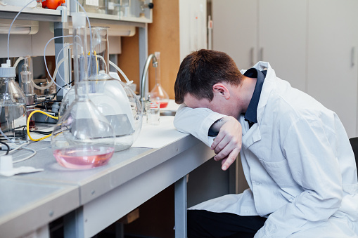 Male scientist sleeps in medical lab