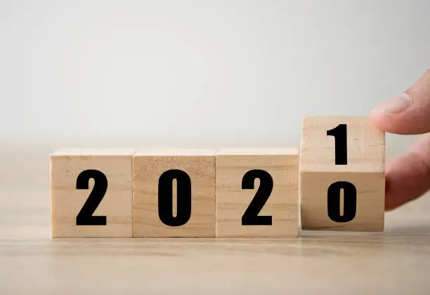 Photo of Hand flipping wooden blocks for change year  2020 to 2021 . New year and holiday concept.