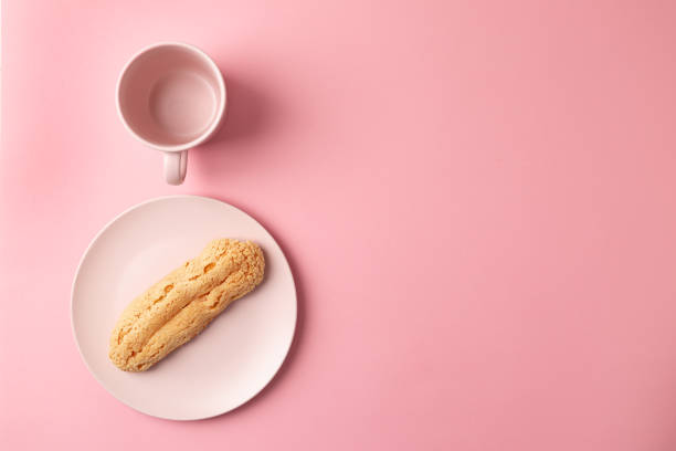 istock Eclair on the plate. Pink pastel background. Dessert. concept, minimalism 1221153647