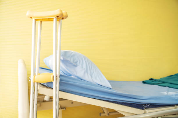istock Empty bed with pillow and blanket and intravenous (IV) stand and walking stick, Walking stick cane used by disable patient for balancing, Healthcare,medical insurance and Physical therapy concept. 1221154276