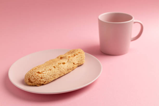 istock Eclair on the plate. Pink pastel background. Dessert concept, minimalism 1221154279