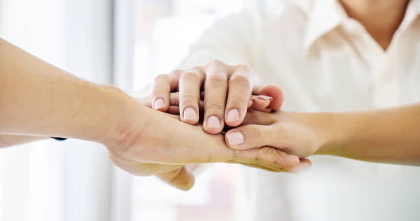 istock Business Team Stack Hands Support Concept. Four business people in formal wear standing and discussing and shake hands and folding their hands on hands of success concept Symbol of cooperation 1221154290