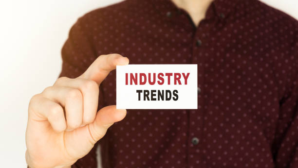 istock Businessman holding a card with text INDUSTRY TRENDS. 1221154483