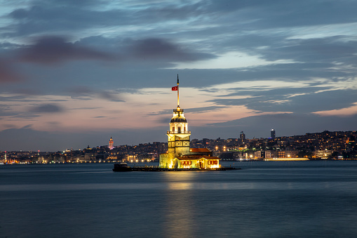 Fiery sunset over Bosphorus with famous Maiden's Tower (Kiz Kulesi) also known as Leander's Tower, symbol of Istanbul, Turkey. Scenic travel background for wallpaper or guide book.