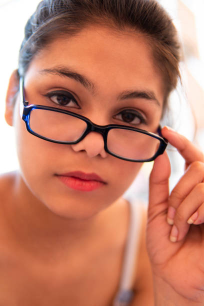 istock Serene woman looking at the camera over eyeglasses with blank expression. 1221155757