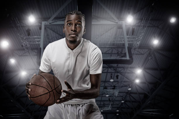 A young african american male basketball player on a basketball court A young african american male basketball player in a fictional stadium college basketball court stock pictures, royalty-free photos & images