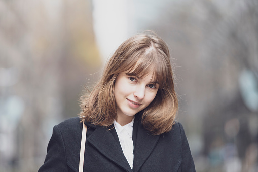 Outdoor portrait of young Russian woman commuting on cloudy day