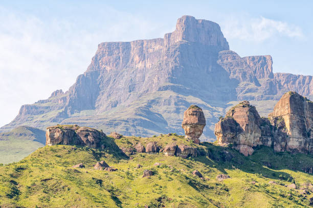 Eastern Buttress of the Amphitheatre visible behind the Policemans Helmet View from the hiking trail to the Policemans Helmet. The Eastern Buttress of the Amphitheatre is visible behind the Policemans Helmet drakensberg mountain range stock pictures, royalty-free photos & images
