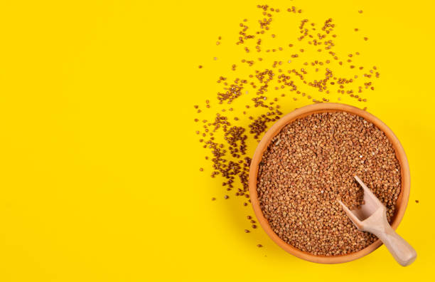 istock Buckwheat groats in a plate on a yellow background. 1221161105