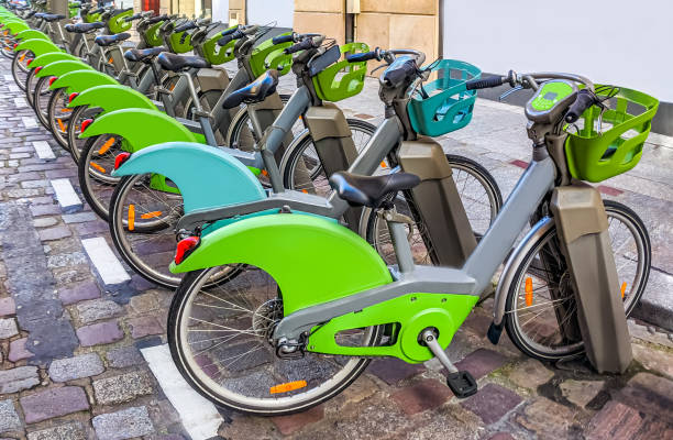 vélos de location électriques, vert et gris, verrouillés sur leurs chargeurs. - gare paris photos et images de collection