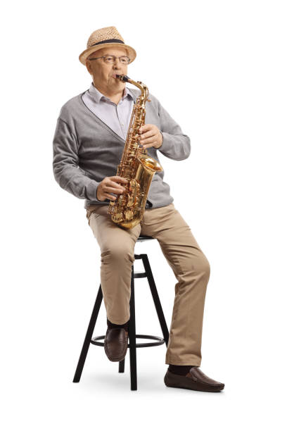 istock Elderly gentleman sitting on a chair and playing a sax 1221164085