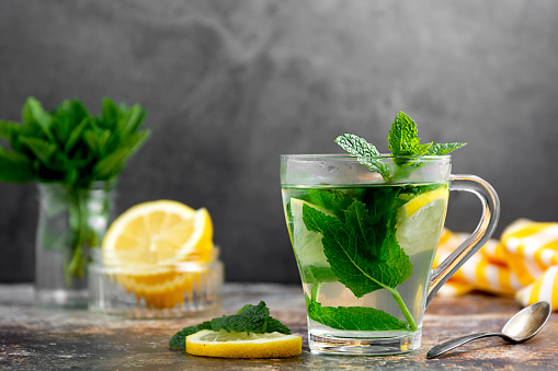 Té de menta con hojas frescas de menta en taza de vidrio, concepto de medicina alternativa, bebida caliente saludable. photo