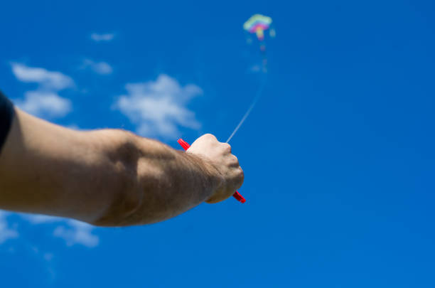 istock hand launches a colored kite in a blue sky 1221164260