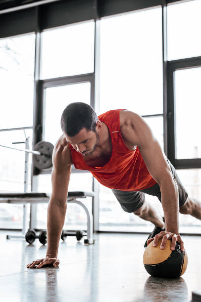 istock strong sportsman doing plank exercising with ball 1221164270
