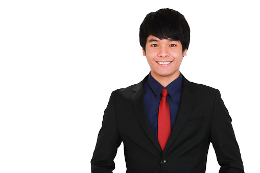Young and handsome smiley and friendly face business Asian man black suit with red necktie standing and looking at camera with self-confident and success gesture on grey background.