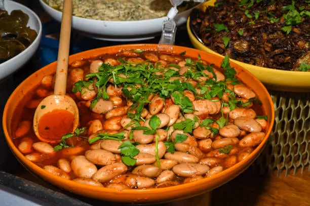 Butter beans in tomato sauce served in a very large pan, during food buffet. Fresh Food Buffet Brunch Catering Dining Eating Party Sharing Concept