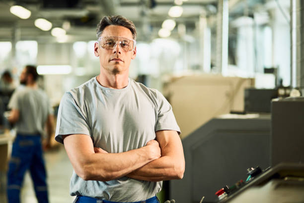 istock Confident CNC machine operator with arms crossed in a factory. 1221173558