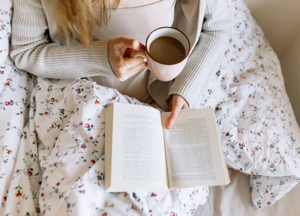 istock Young beautiful woman enjoying with coffee in bed 1221174019